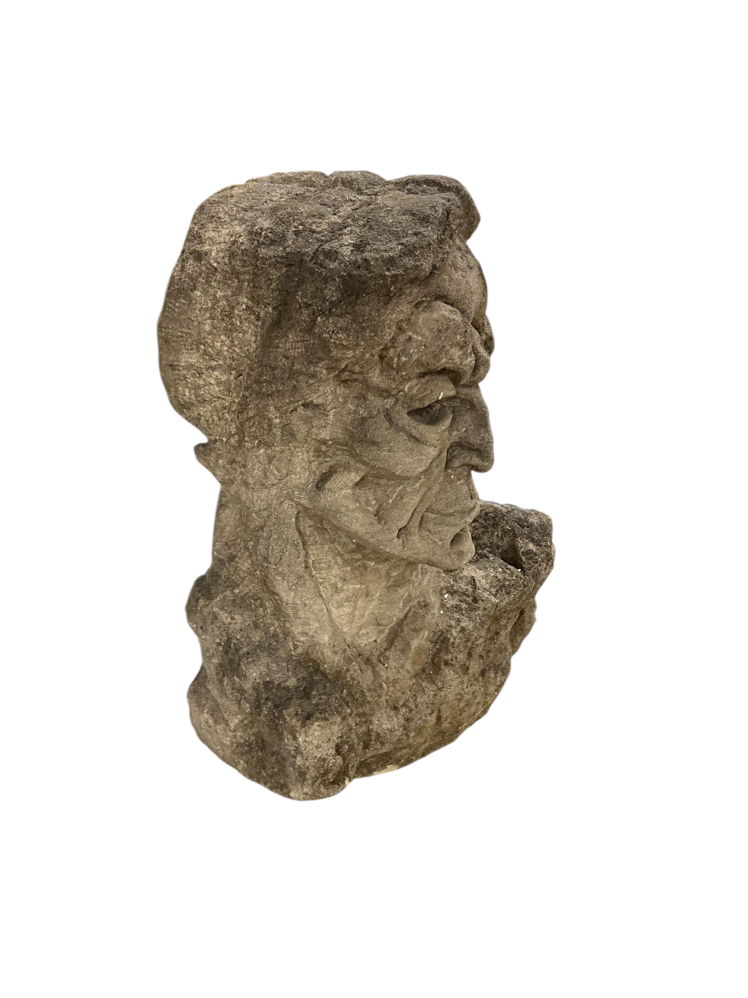 A carved stone head, height 69cm